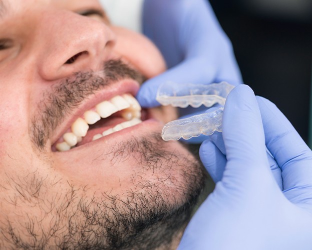 Dentist checking the fit of an Invisalign tray